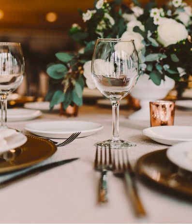 Elegant table setting with white plates, glassware, and a floral centerpiece for a formal dinner to impress guests.