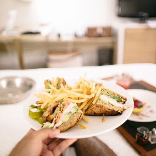 A plate with fried items and dipping sauce, a glass of juice, and a cozy kitchen backdrop.