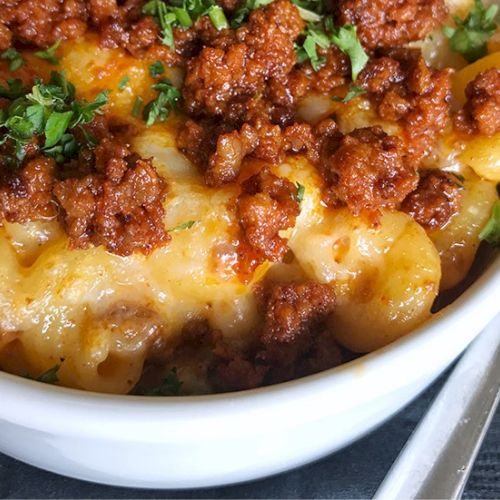 A bubbling skillet of cheesy, golden-brown chicken or pasta bake topped with herbs and parmesan, bright with a fresh garnish.